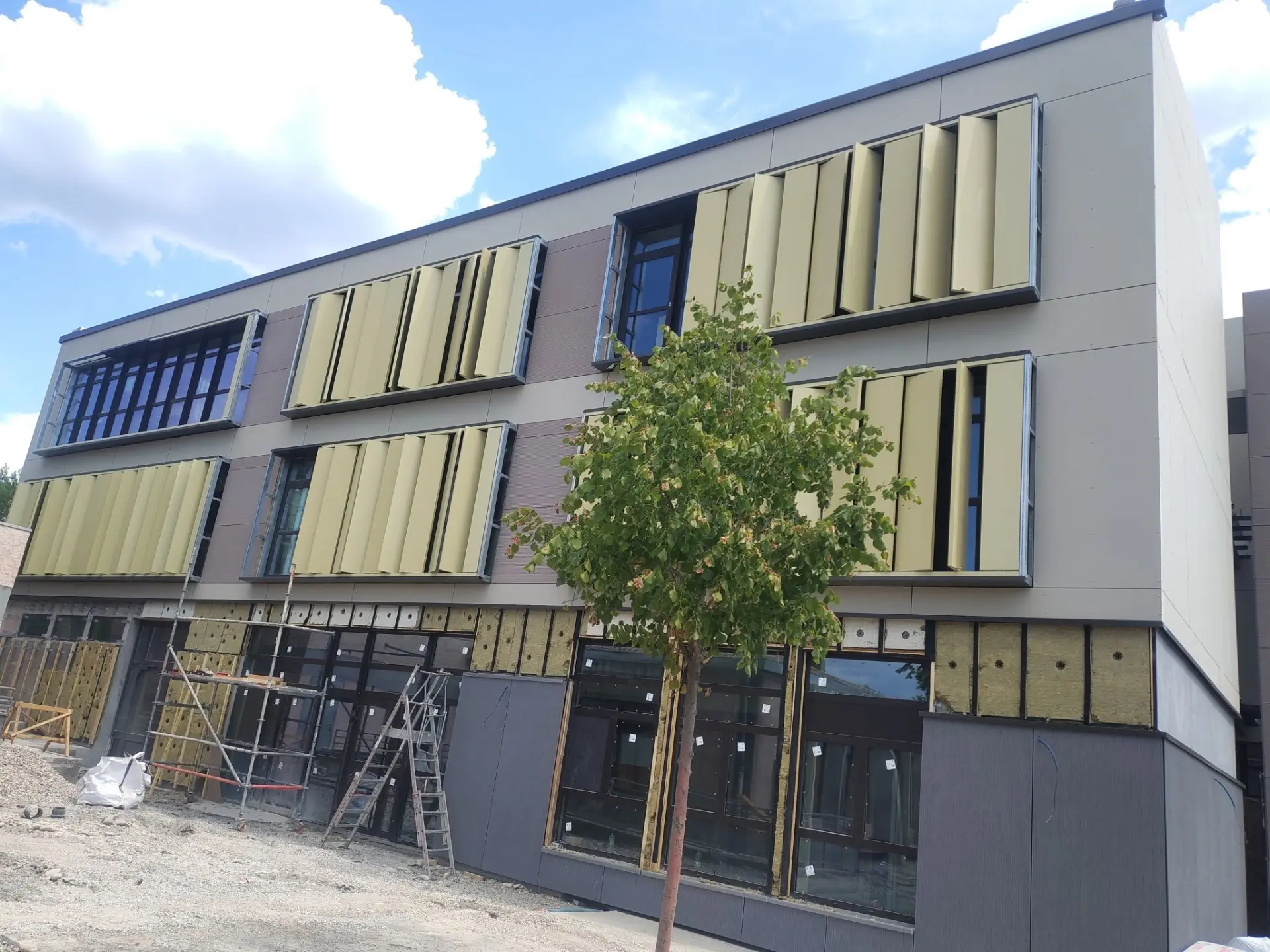 Façade du groupe scolaire Le Colombier à Manosque en cours d'habillage en bardage stratifié, avec brise-soleil